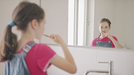 Little girl brushing her teeth in the morning.