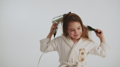 Little girl combing her hair.