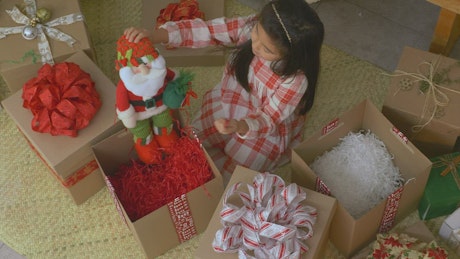 Little girl opening gifts at christmas.