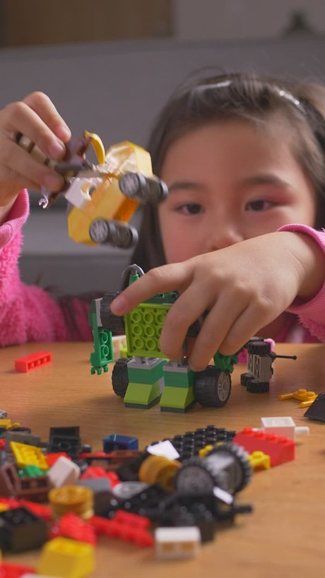 Little girl playing with her legos.