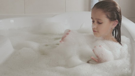 Little girl taking a bath in the jacuzzi.