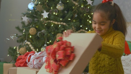 Little girl very excited opening presents at christmas.