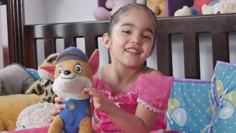 Little smiling girl with a stuffed toy.