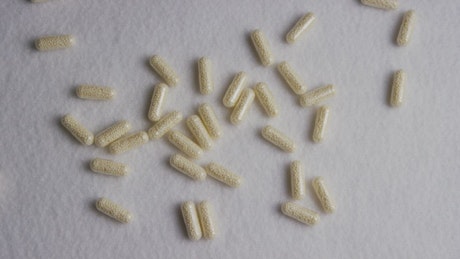 Little white pills on a white texture
