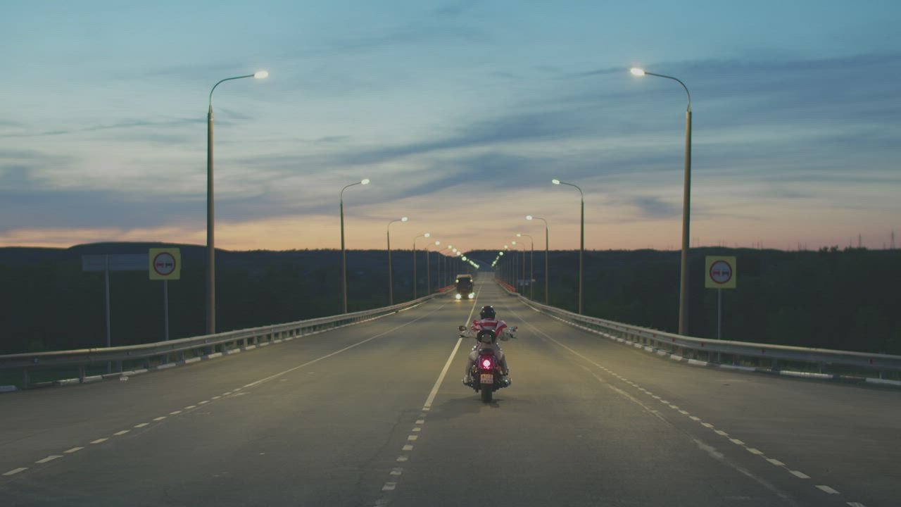 ⁣L judibolaslot one motorcyclist driving down the highway at night