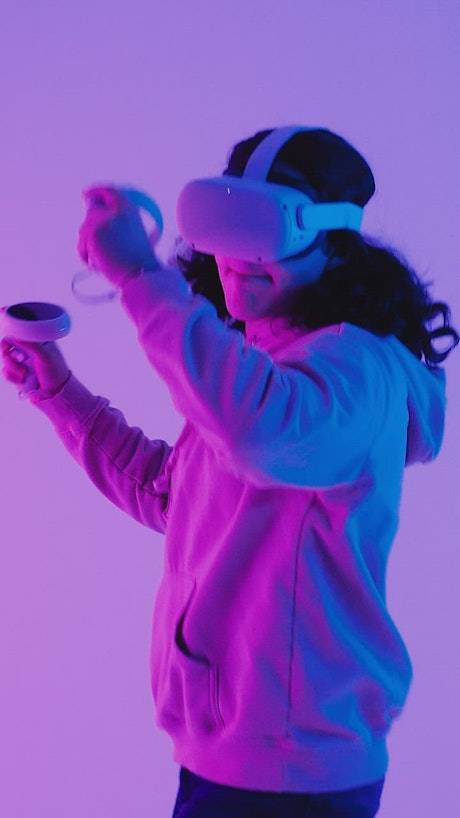 Long-haired boy playing VR video games.