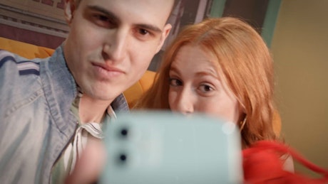 Lovely couple makes a funny video with lobster plushie in front of a smartphone.