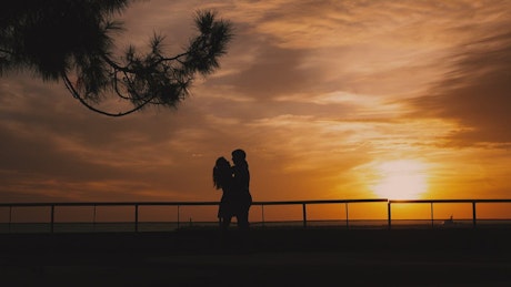 情侣们在浪漫的日落中拥抱在一起