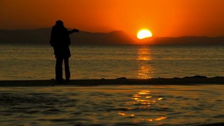 情侣们在海边日落时自拍