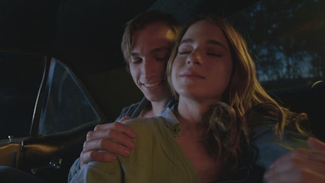 Loving couple inside a car at night