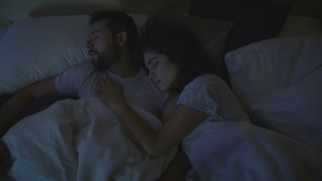 Loving couple sleeping together at night