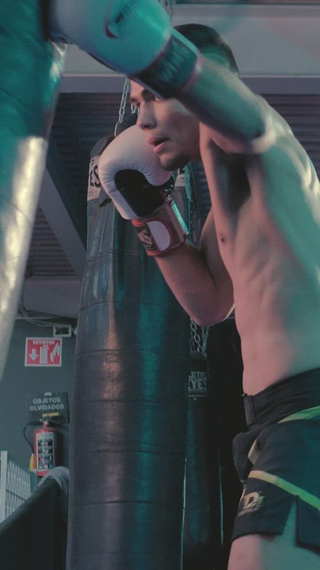 Low view of a boxer punching a boxing bag.