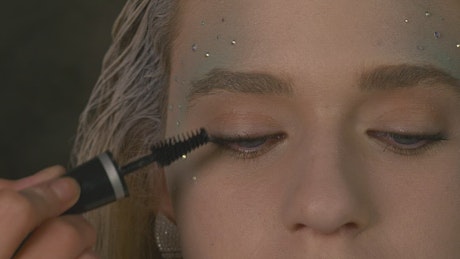 Makeup artist applying mascara.