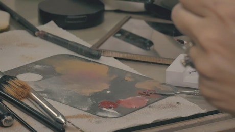 Makeup artist mixing makeup on a palette