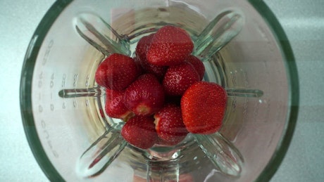 Making a strawberry smoothie.