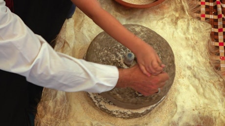Making wheat flour in a rotating stone.
