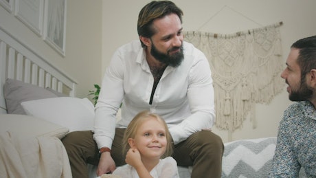 Male couple and daughter at home.