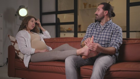 Man and pregnant woman chatting comfortably.