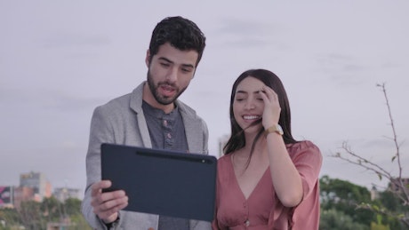 Man and woman outdoors during a video call.