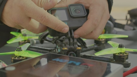 Man assembling a camera to a drone.