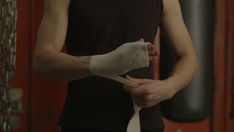 Man bandaging his hand before boxing