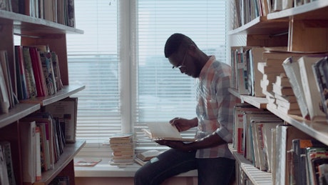 Man checking books in the library.