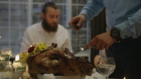 Man cutting the turkey on Thanksgiving dinner