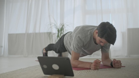 Man doing plank exercise in his living room