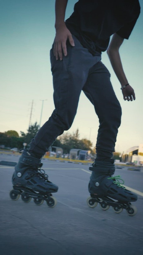 Man doing tricks with roller skates in a parking lot.