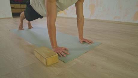 Man doing yoga on a mat on the floor.