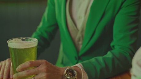 Man drinking a beer on st patrick's day.