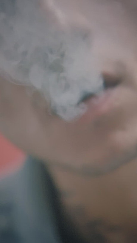 Man exhaling marijuana smoke