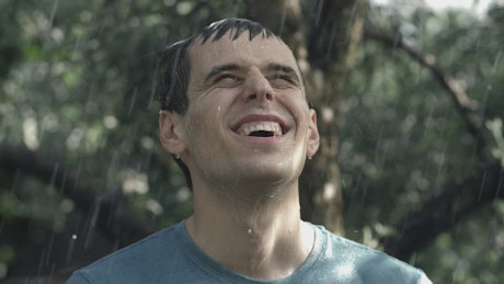Man happily getting wet in the rain.
