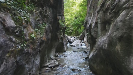 Man hiking in a stream between rocks