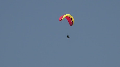 Man in a red paraglide in the sky