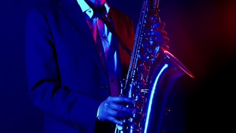 Man in a suit playing a saxophone in a jazz club.