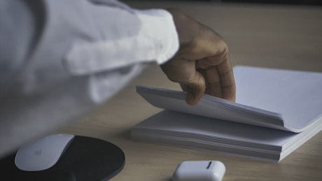 Man in an office taking a white sheet of paper