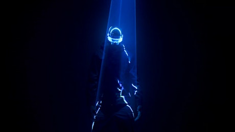 Man in cyberpunk glasses dances under neon lights.