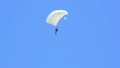 Man in white parachute falling down.