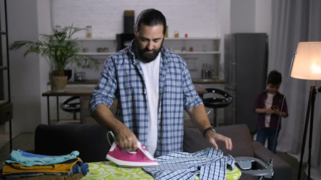 Man ironing his clothes.