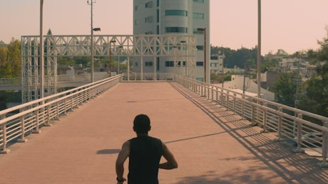 一名男子在城市的人行天桥上慢跑