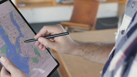Man locating an area on a map on a tablet.