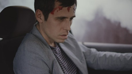 Man looking dazed and confused after a car crash.