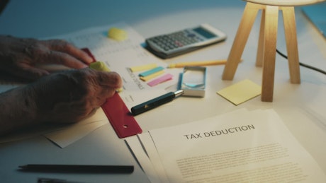 Man makes accounts of his finances and prepares his tax deduction.