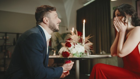 Man makes surprise marriage proposal to girlfriend.