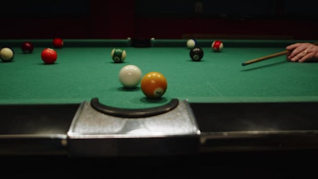 Man participating in a game of billiards.