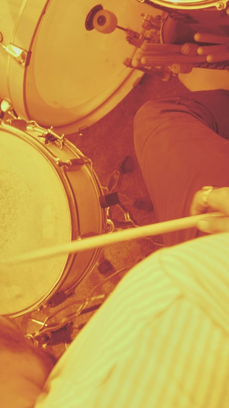 Man playing drums with sepia filter.