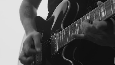 Man playing electric guitar black and white.