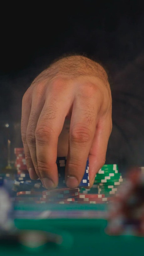 Man playing with a tower of poker chips.