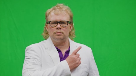 Man pointing at copy space on green screen background.
